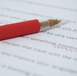 close up of essay being corrected with red pen