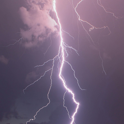 Bolt of white lightning against a purple sky
