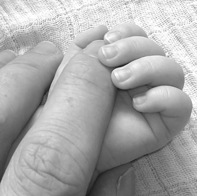 Baby hand gripping adult hand; Black and white