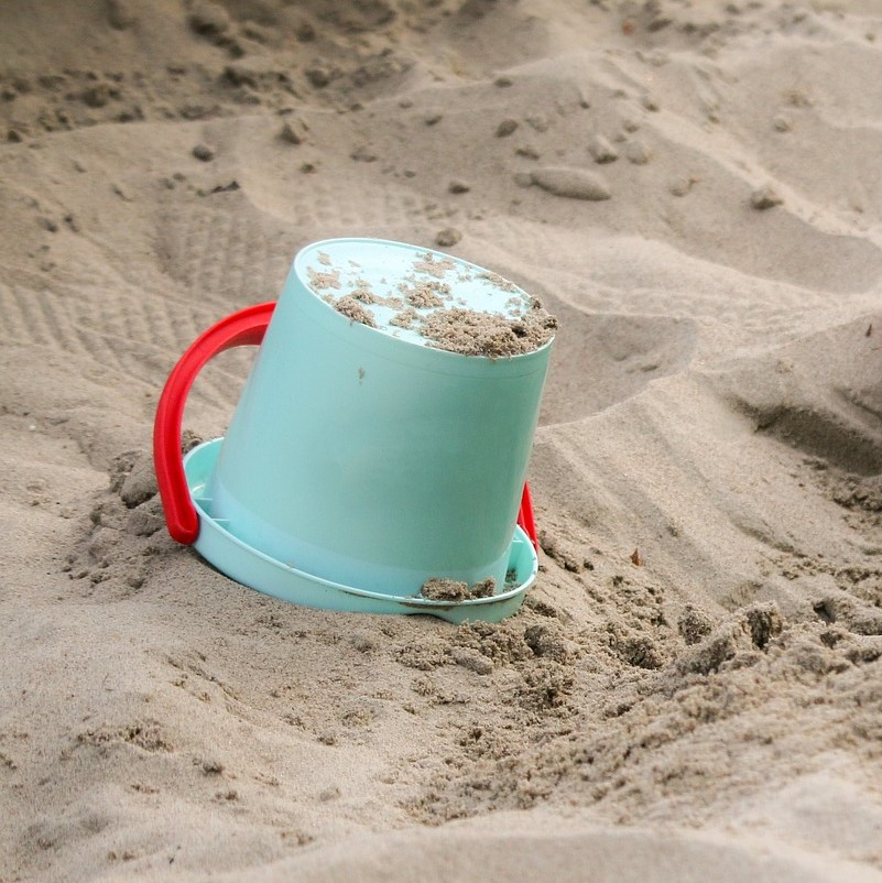 Teal pail in the sand