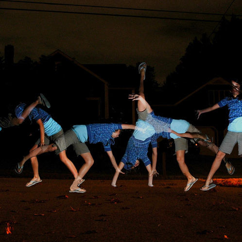 Group of people doing cartwheels outside at night