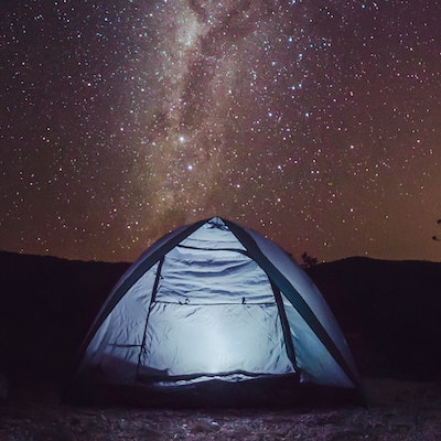 camping tent under a night sky of stars