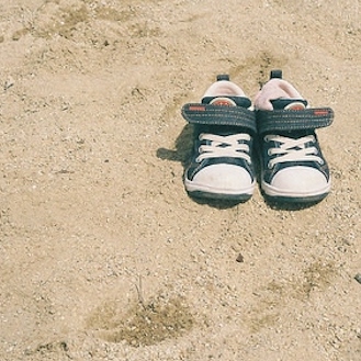 baby shoes in the sand