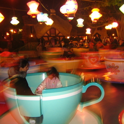 Adult and child spinning on teacup ride