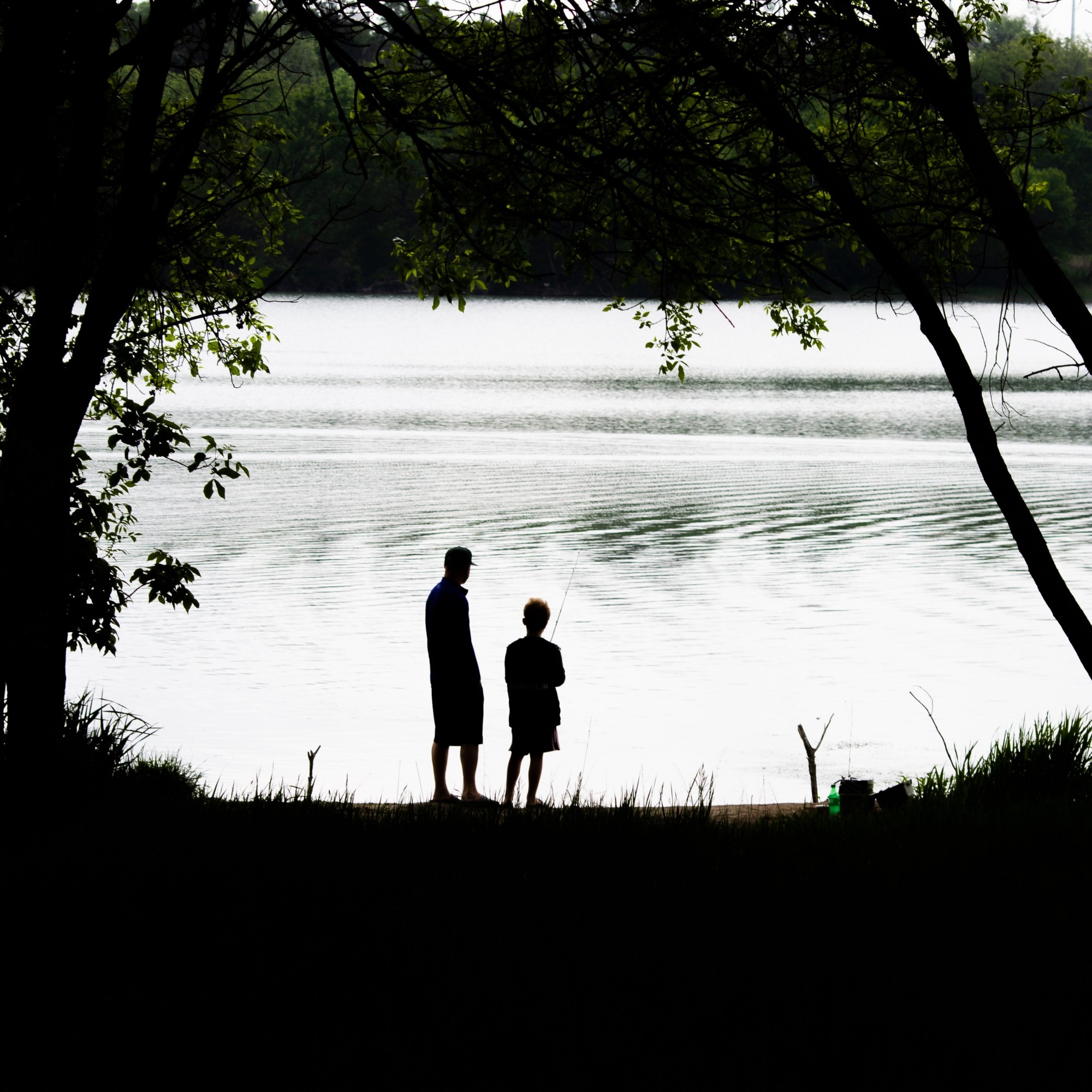 Two people stand at a lake