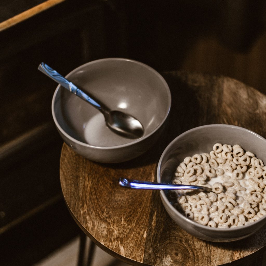 Bowls of cereal sit on a wooden table