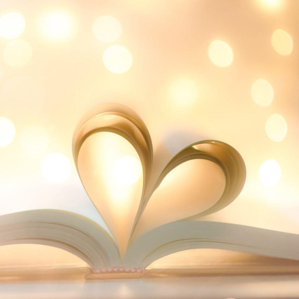 A book lays open with two pages lifted up to form the shape of a heart