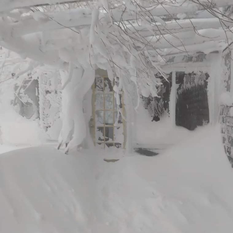 Photo of huge snow drifts by a house
