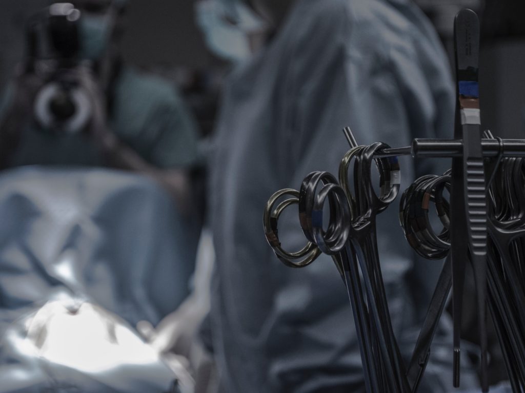 Blurred image of operating room with medical tools in focus in forefront