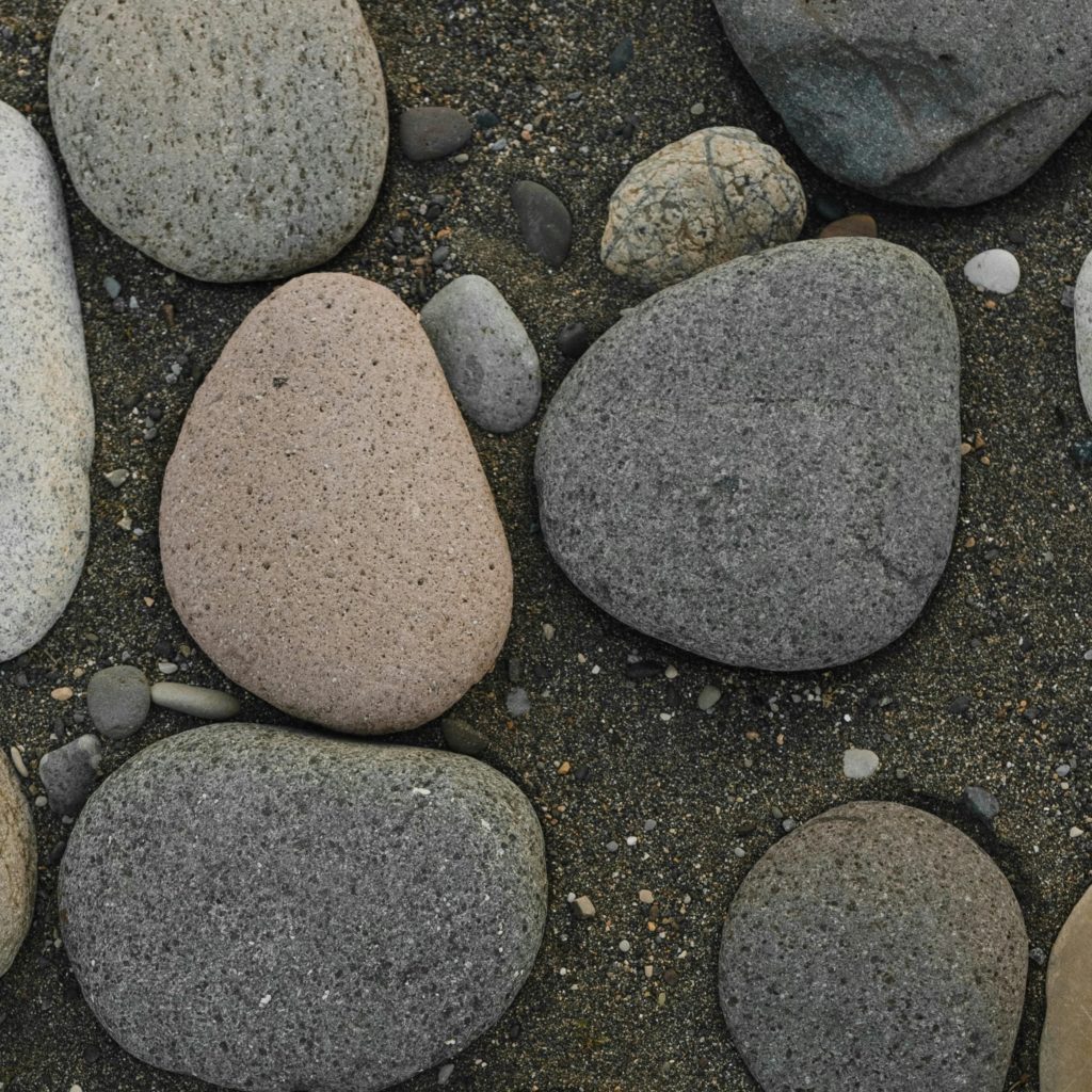 gray, pink, and black stones in sand